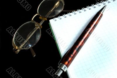 glasses, pen and notebook