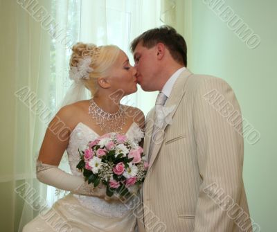 Wedding kiss of young newlyweds couple