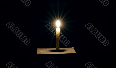 Burning candle on a black background