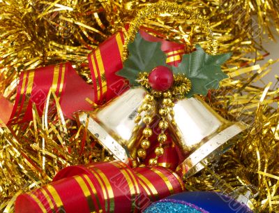 Christmas bells and ribbon on gold tinsel
