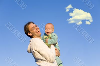 A father hold baby in hands on sunset