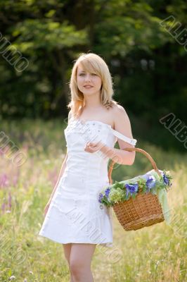 Sexy girl walk with basket on meadow