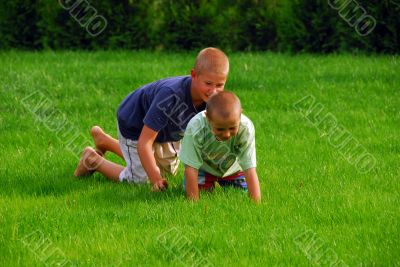 two boys play on the grass