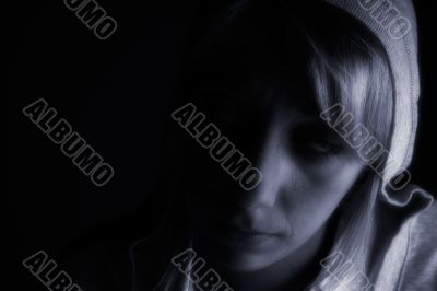Studio portrait of a long blond girl in the dark