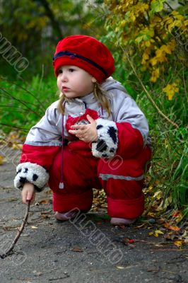Little girl sitting in the fall park