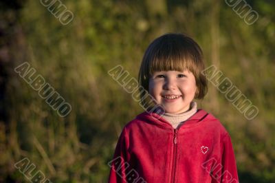 Laughing girl in sunset lights in the grass