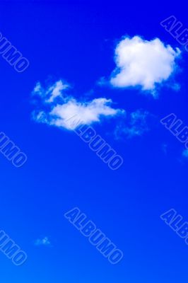 Couple of clouds in vivid blue sky