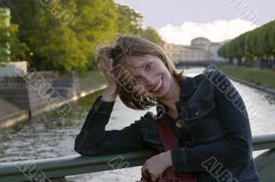Smiling girl in sunset lights on the bridge