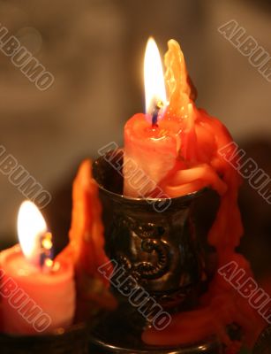 red candle flaming upon dark background