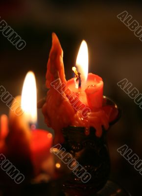 red candle flaming upon dark background