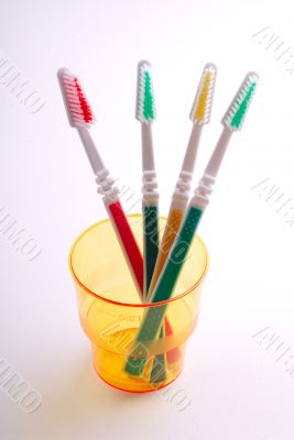 four tooth-brushes in  glass