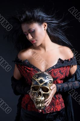Beautiful brazilian woman holding a skull