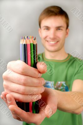  multi-coloured pencils in hands