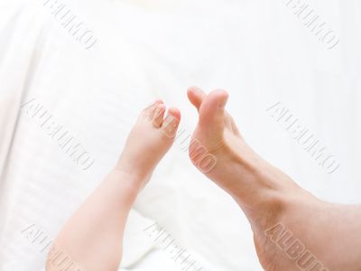 Baby`s leg toching to father`s leg