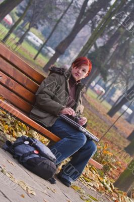 Redheaded girl in an autumn park