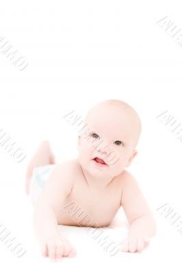Funny little baby lying on white bed over white background