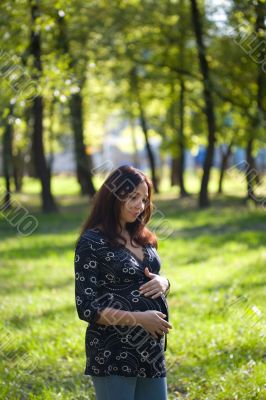 Pleasured pregnant woman in blue jeans do daily promenade