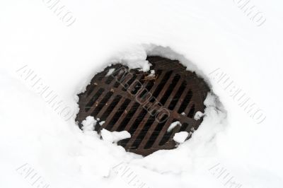 Manhole cover in white snow