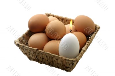 few eggs in a basket with a candle