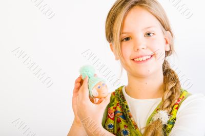 Young girl with painted egg with hat