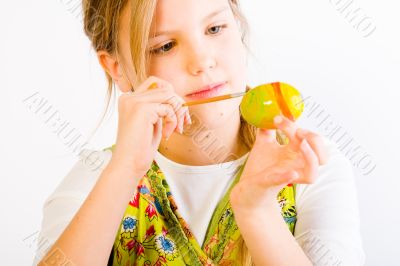 Young girl painting an easter eggs