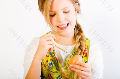 Young girl having fun painting eggs for easter