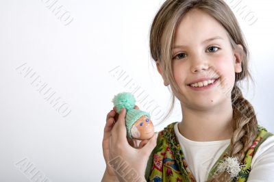 Young girl with painted egg with hat