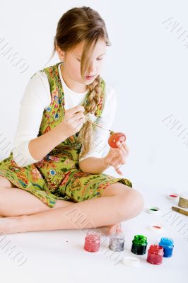 Young girl painting her easter eggs