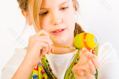 Young girl painting easter eggs