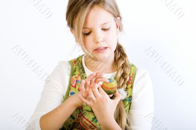 Young girl painting examening her easter egg
