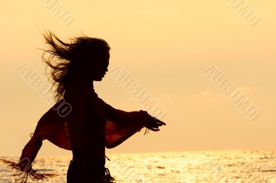 girl silhouette on golden sunset sky background