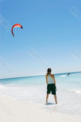 girl looking at kite surfer in the sea