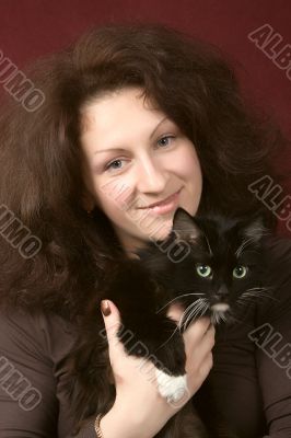 Portrait of the young smiling woman with a cat.