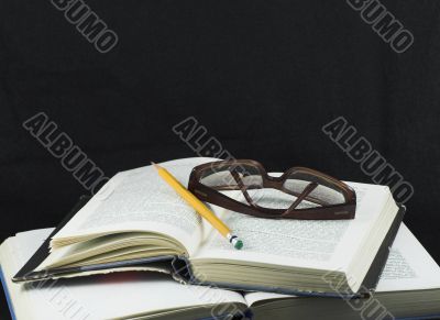 Pencil and glasses on a book