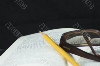 Pencil and glasses on a book