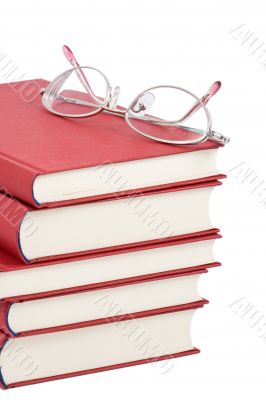 stack of red books with eyeglasses