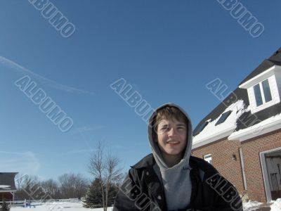 young teen boy with hood up in snow scene