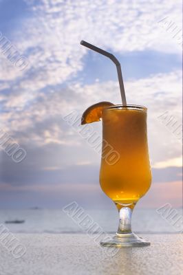 glass of orange juice on sky background