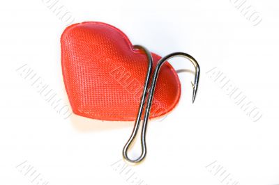 Red heart with a fishing hook on a white background