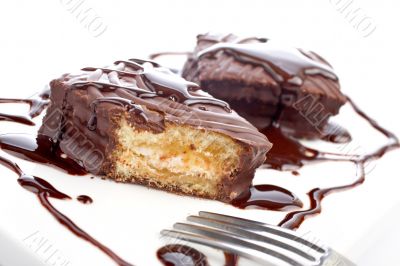 Two chocolate cakes with syrup and the fork