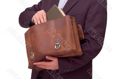 man putting a book into the briefcase
