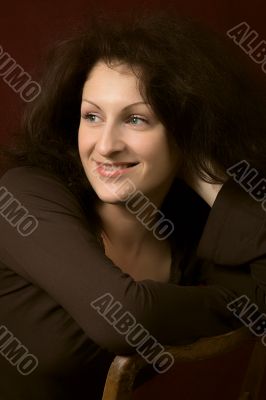 Portrait of the young smiling woman on a dark background.