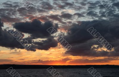 dark and light clouds on a sunset over Volga.