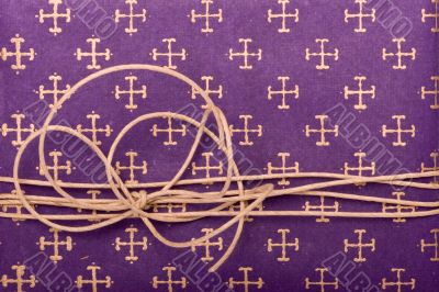Paper cord knot over purple wrapping paper