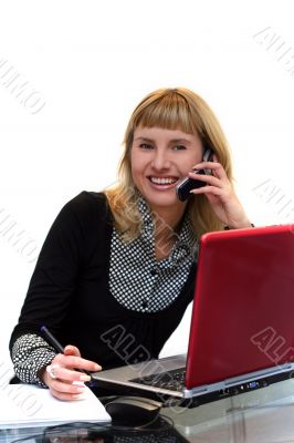 woman is writing and calling by phone sitting near laptop