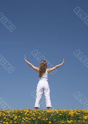 Young woman exercising in dandelion field