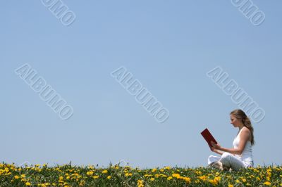 Young woman reading a book outdoors