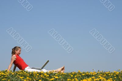 Young woman relaxing with laptop outdoors