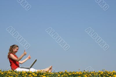 Smiling girl with laptop, thumbs up