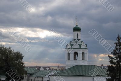 Sun beams through clouds over church